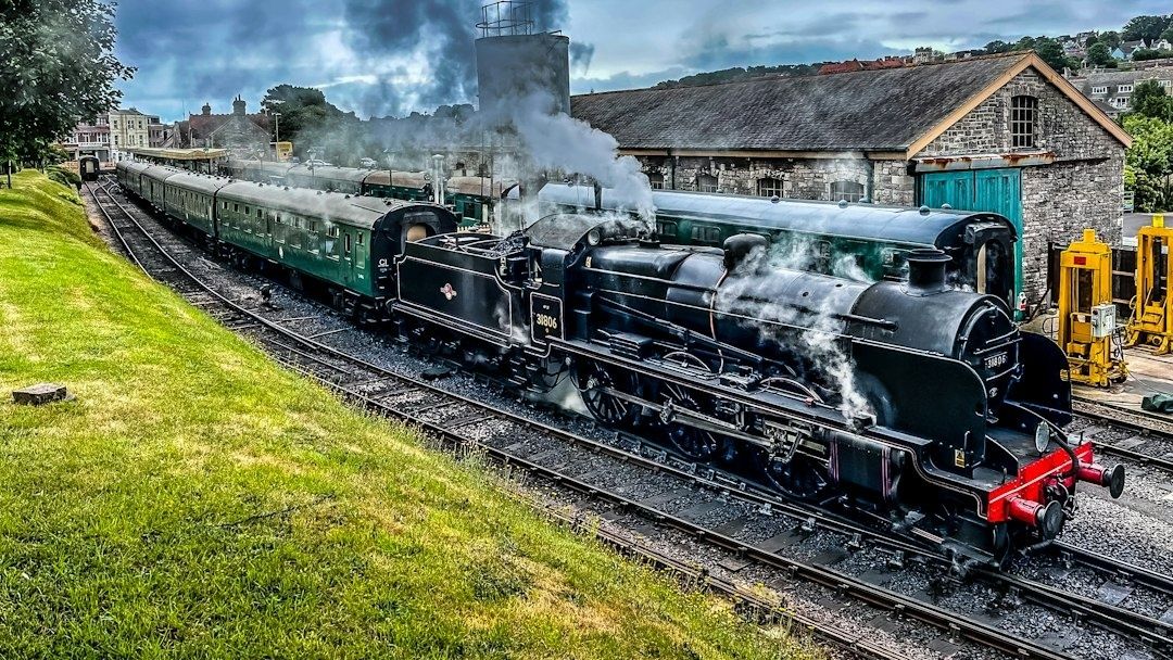 Stoomlocomotief met rijtuigen op een stationsemplacement